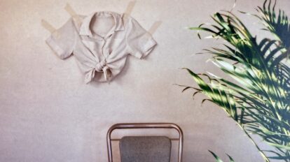 An image of a chair with an article of clothing on the wall.